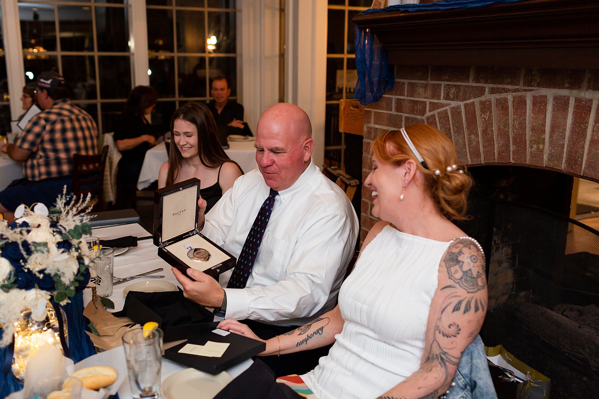 A groom opens a Delvey compass given to him as a wedding gift by the bride.