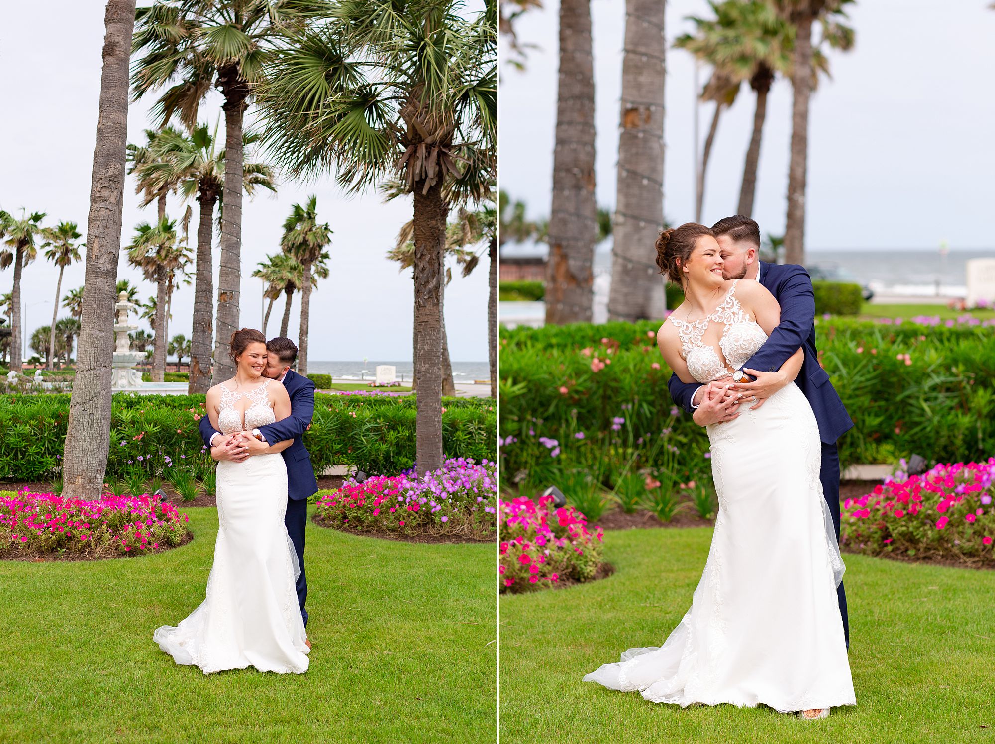 A bride and groom stand on a green lawn with palm trees and the ocean behind them.