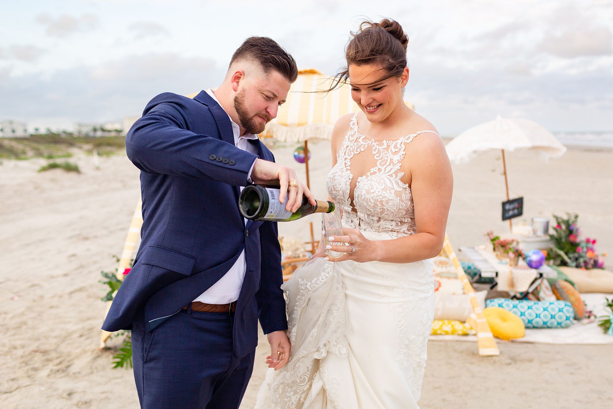 A groom pours champagne for his bride.