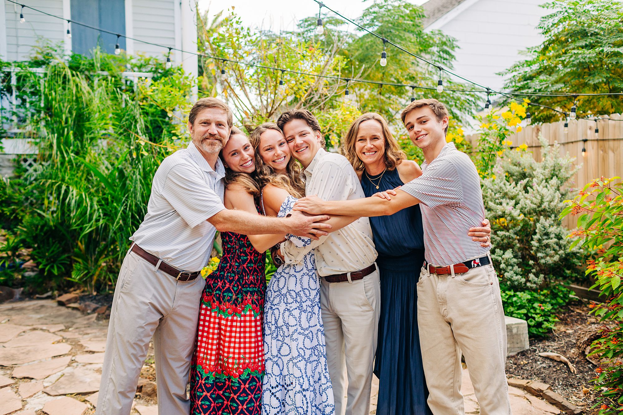 A bride to be's family does a group hug to celebrate her engagement.